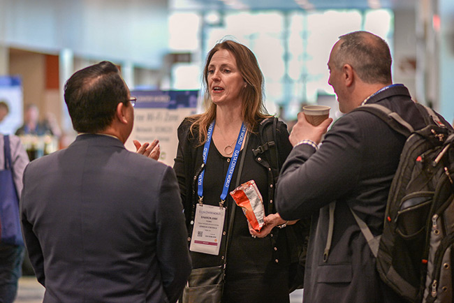 A woman and two men networking in the Data Center World expo hall